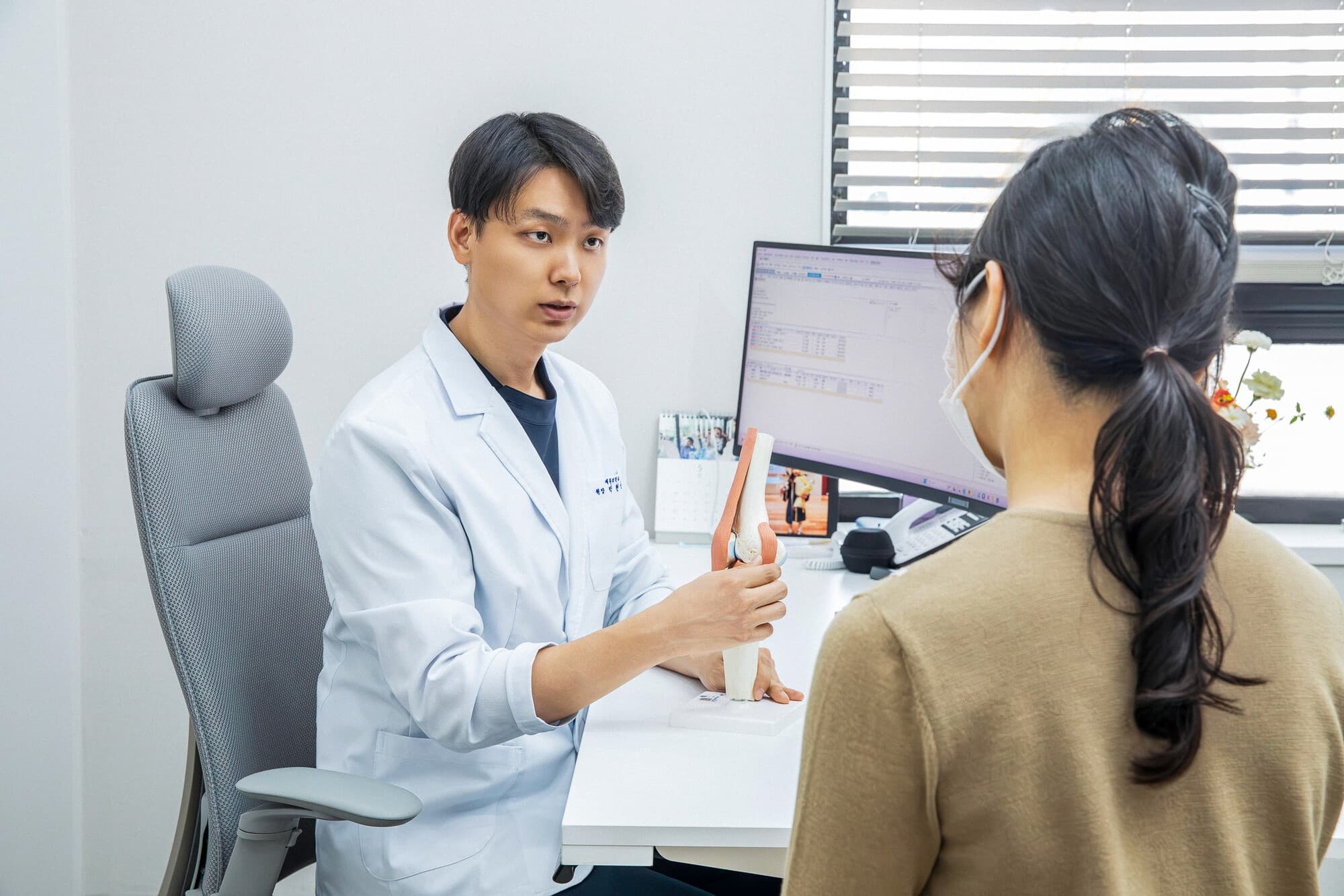 인체 모형으로 설명하며 상담하는 모습